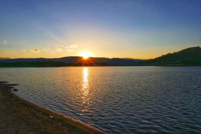 Scenic view of lake against sky during sunset
