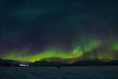 Scenic view of northern lights and star field against sky at night
