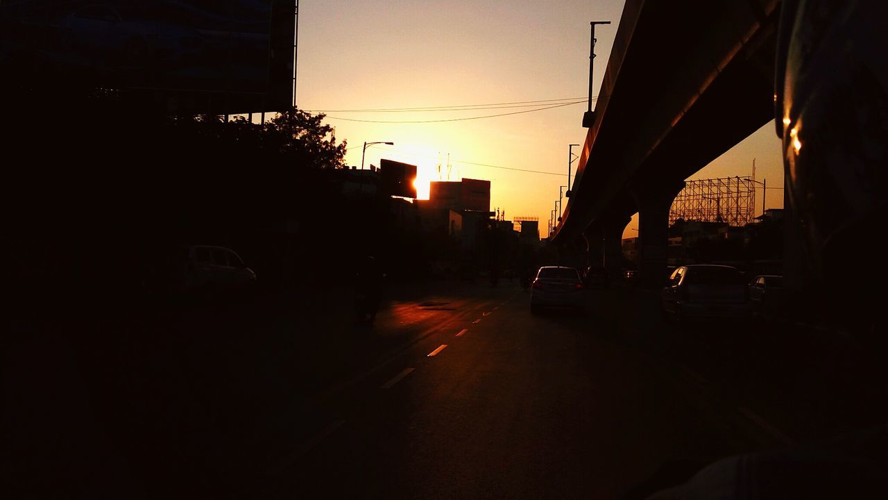 CARS ON ROAD AGAINST SKY DURING SUNSET