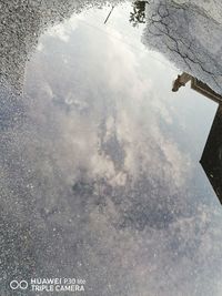 Reflection of sky in puddle on road