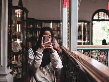 Full length of man photographing through smart phone