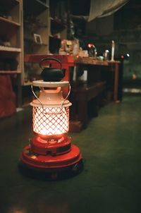 Close-up of illuminated lamp on table