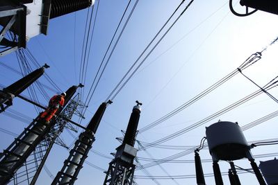 Low angle view of electricity pylon against clear sky