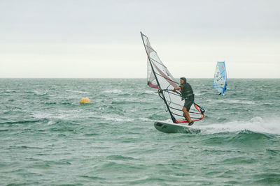 Full length of man windsurfing on sea