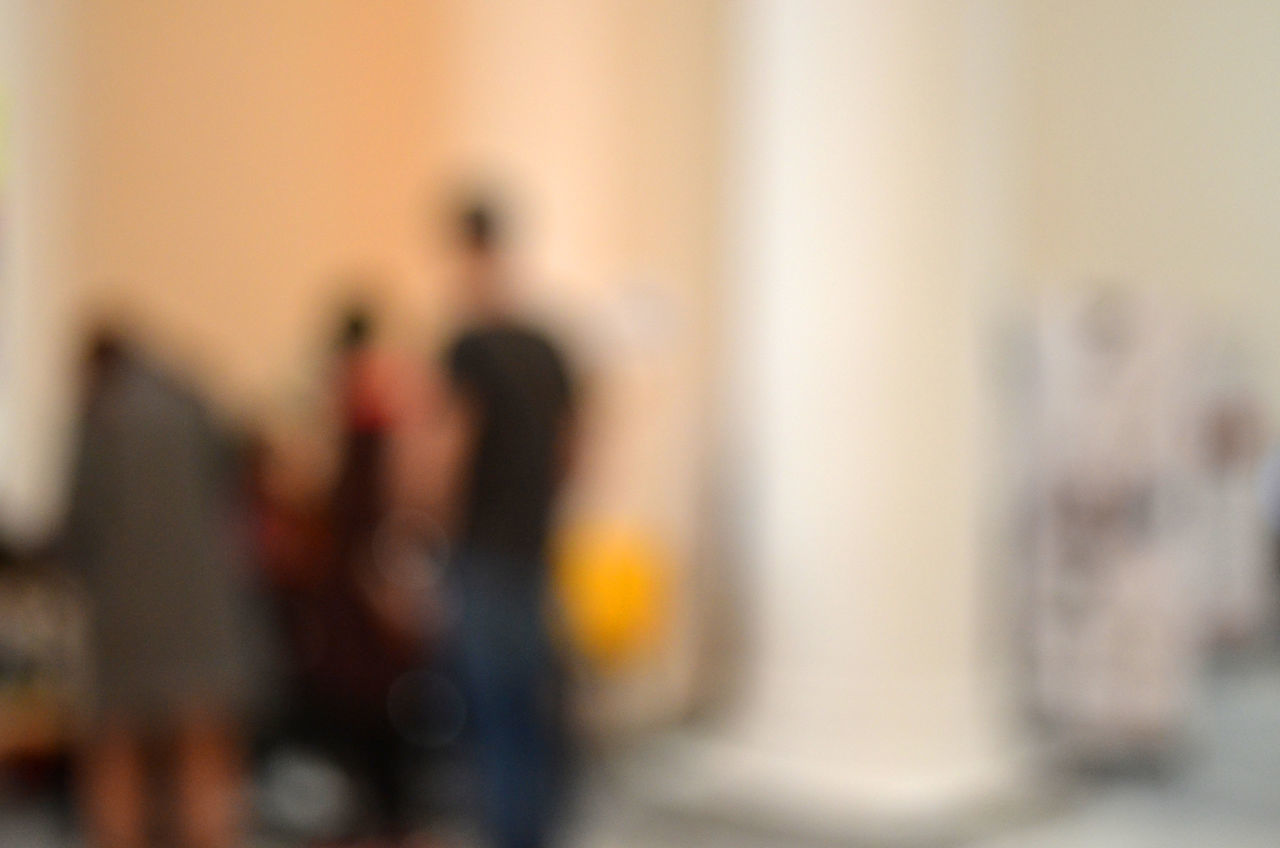 DEFOCUSED IMAGE OF MAN AND WOMAN STANDING AGAINST WALL