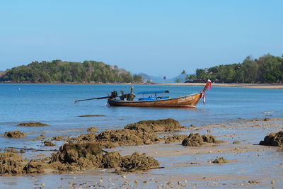 Boat moored on sea against clear sky