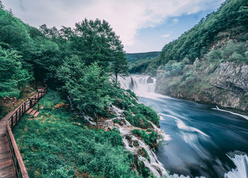 Scenic view of waterfall against sky