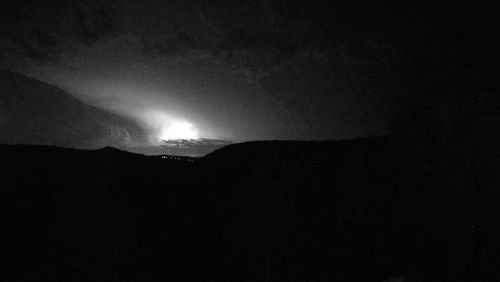 Low angle view of silhouette mountain against sky at night