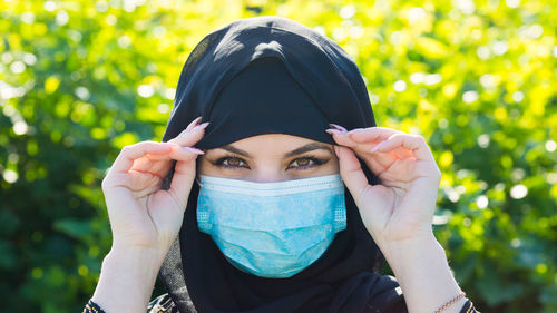 Close-up portrait of woman wearing hijab and mask