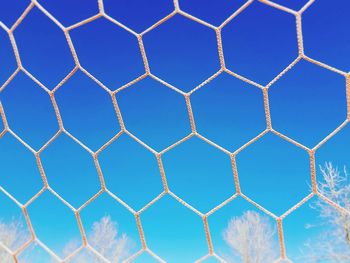 Full frame shot of chainlink fence against blue sky