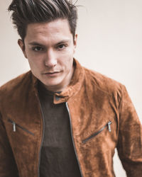 Portrait of young man standing against white background