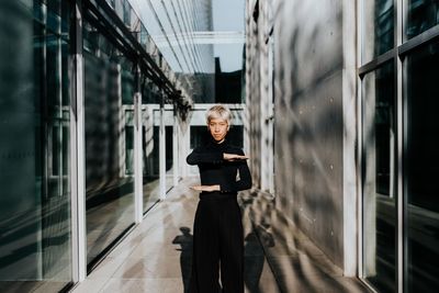 Portrait of woman photographing through window