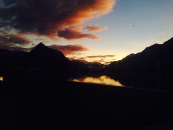 Scenic view of silhouette mountains against dramatic sky