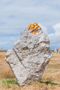 Rock formation on field against sky