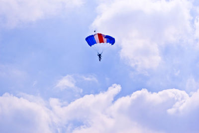 Low angle view of person paragliding against sky