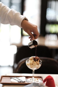 Close-up of person hand pouring drink in glass