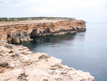 Rock formations by sea against sky