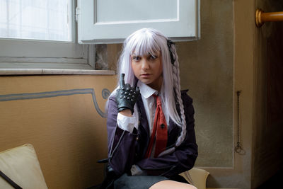 Portrait of student wearing gray hair sitting on seat