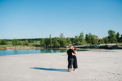 Rear view of woman on beach against clear sky