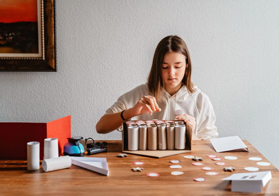 Teen girl making handmade advent calendar house from toilet paper rolls. sustainable christmas,