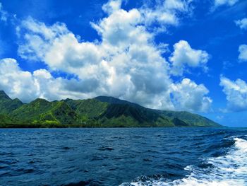 Scenic view of sea and mountains against blue sky