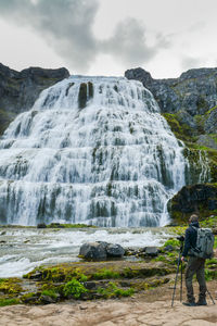 Rear view of man looking at waterfall