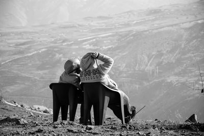 Rear view of couple sitting on land