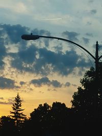 Silhouette of trees against cloudy sky