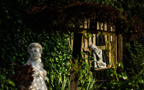 Statue against trees and plants