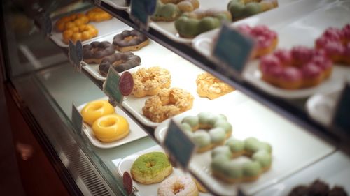 Donuts in display cabinet at store for sale