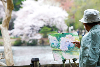 Rear view of man painting outdoors