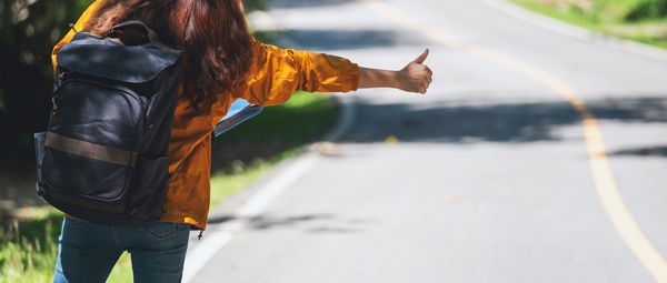 Rear view of woman walking on road