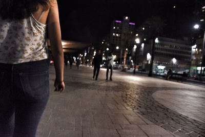 Man walking on illuminated street at night