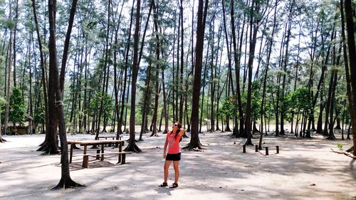 Woman standing against trees