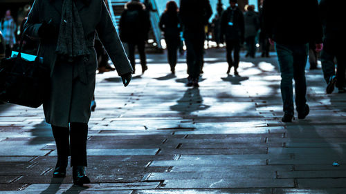 Low section of woman walking on sidewalk