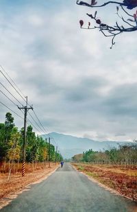 Man riding motorcycle on road against sky