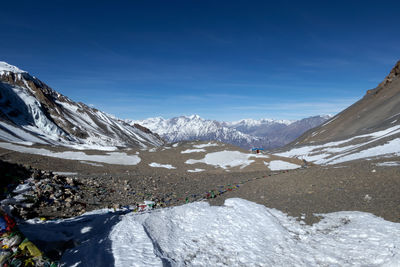 Scenic view of snowcapped mountains against blue sky