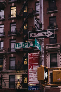 Low angle view of information sign against buildings in city