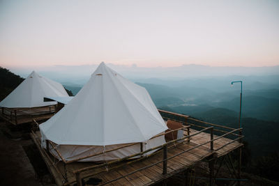 Tent on mountain against clear sky during sunset