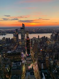 High angle view of illuminated city against sky during sunset