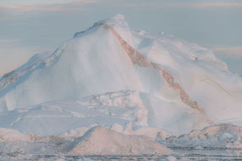 Aerial view of snow covered land and sea against sky