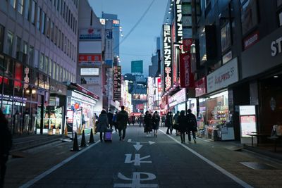 People walking on city street amidst buildings