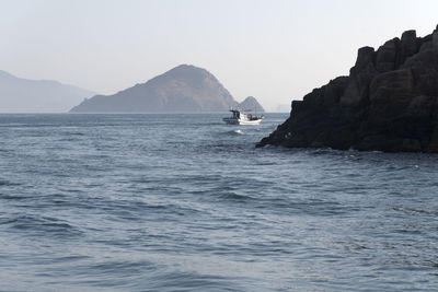 Scenic view of sea and mountains against clear sky