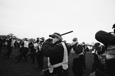 Rear view of people standing against sky