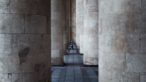 Boy walking amidst columns at monument