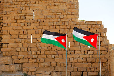 Low angle view of flag against brick wall