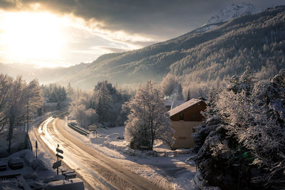 Panoramic view of trees and snowy mountains against sky during winter