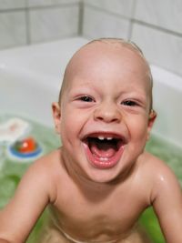 Portrait of smiling naked baby boy in bathtub