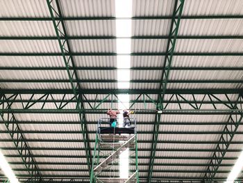 Low angle view of man working on ceiling