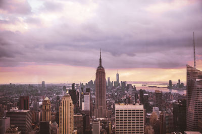 Modern buildings in city against cloudy sky